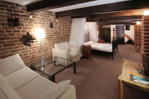 a living room with white furniture and a brick wall at Zamek Reszel in Reszel