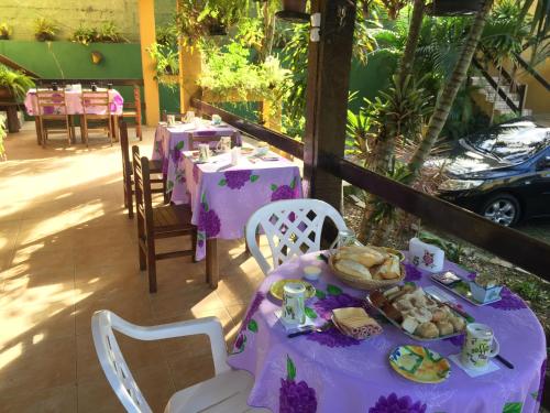 een tafel met een paars tafelkleed met voedsel erop bij Abal Pousada in Búzios