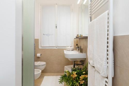 a bathroom with a sink and a toilet and a window at San Polo Near Rialto Fish Market in Venice