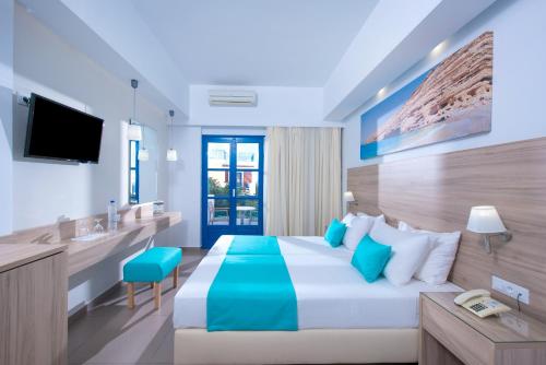 a hotel room with a bed and a television at Astra Village & Suites in Hersonissos