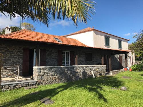 a stone house with a red roof at Casa dos Reis in Calheta