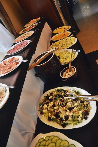 a long table with plates of food on it at Dwór w Zabużu in Zabuże