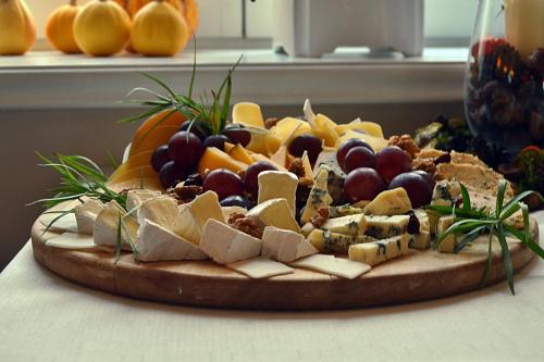 a plate of cheese and fruit on a table at Dwór w Zabużu in Zabuże