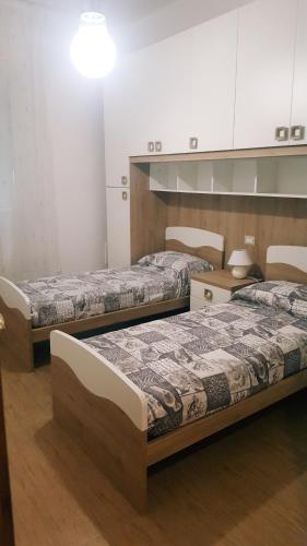 ラ・スペツィアにあるCasa Federica 1のベッド2台とテーブルが備わる客室です。