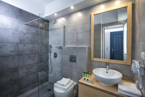 a bathroom with a shower and a sink and a toilet at Astra Village & Suites in Hersonissos