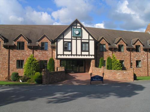 a large brick building with a clock on it at Woodbury Park Hotel & Spa in Exeter