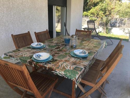 une table avec des chaises et un tissu de table avec des assiettes dans l'établissement Villa E Lecce, à Santa-Lucia-di-Moriani