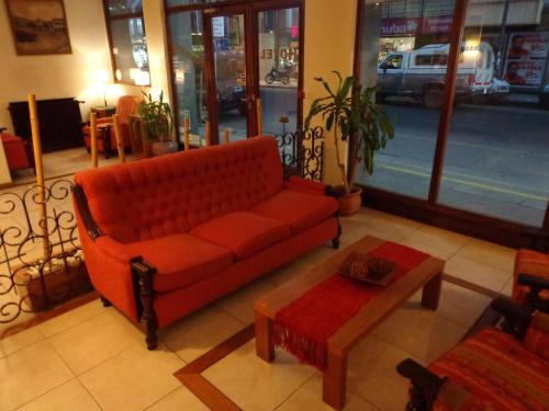 a living room with a red couch and a table at Hotel Compostela in Mar del Plata
