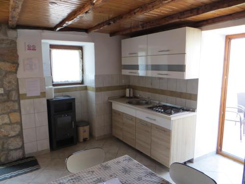 a kitchen with white cabinets and a stove top oven at Holiday Home Pernat in Valun