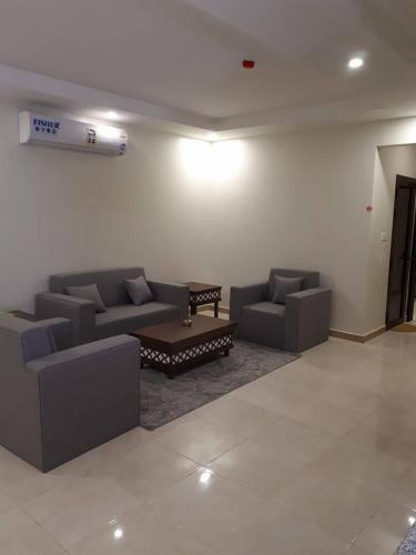 a living room with couches and a coffee table at تاج الخليج للشقق المخدومة in Dammam