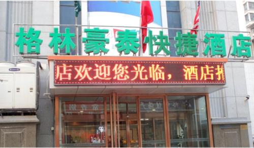 une pancarte sur un bâtiment avec inscription chinoise sur celui-ci dans l'établissement GreenTree Inn Weihai Qingdao North Road Branch, à Weihai