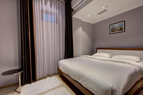 a bedroom with a bed and a large window at Garden Hotel in Bishkek