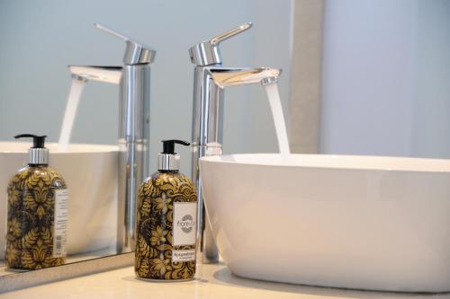 a bathroom with two bottles of soap and a sink at Hotel Anna in Platis Yialos Mykonos