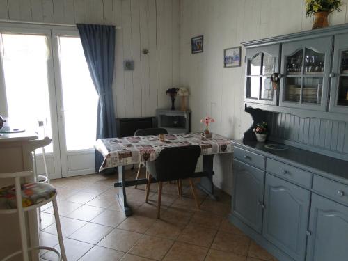 une cuisine avec une table et des chaises ainsi qu'une fenêtre dans l'établissement La Petite Maison sur l'Ile de Ré, à La Flotte