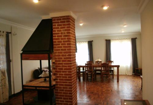 a living room with a brick pillar and a dining room at Marciloui in Antsirabe