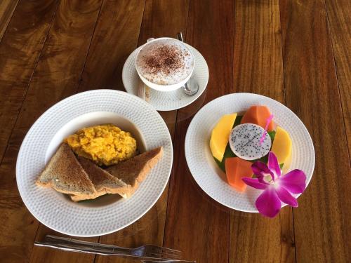 a table with two plates of food and a cup of coffee at Thai House Resort in Hua Hin