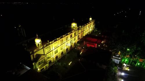 a building with lights on it at night at Jal Mahal Resort and Spa in Mysore
