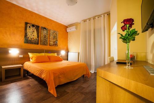 Un dormitorio con una cama y un jarrón con una flor en B&B Portacastello, en Castel Lagopesole