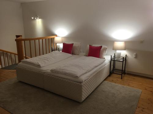 モントゼーにあるWohnung Schloss Mondseeの赤い枕2つ付きのベッド1台