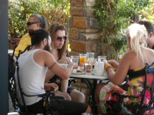 a group of people sitting at a table at Galini Bungalows in Kionia