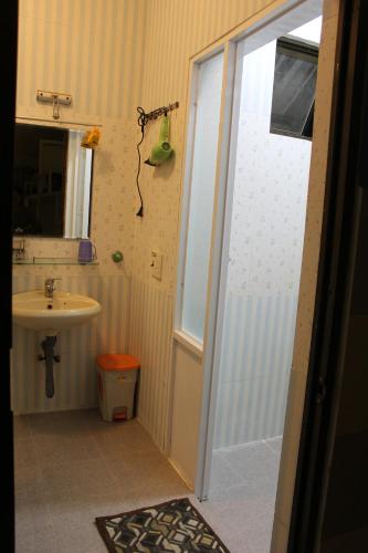 a bathroom with a sink and a shower backdoor at DaLat Sky Hostel in Da Lat