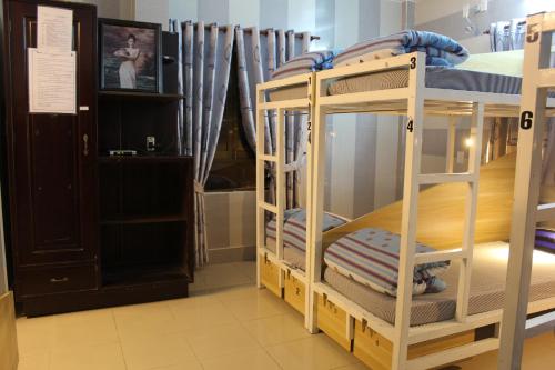 a bunk bed room with two bunk beds and a tv at DaLat Sky Hostel in Da Lat