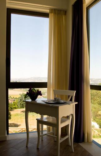 a table and a chair in front of a window at Agriturismo Il Falco in SantʼElpidio a Mare