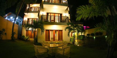 a building with a table in front of it at night at Hotel Shanelo in Negombo