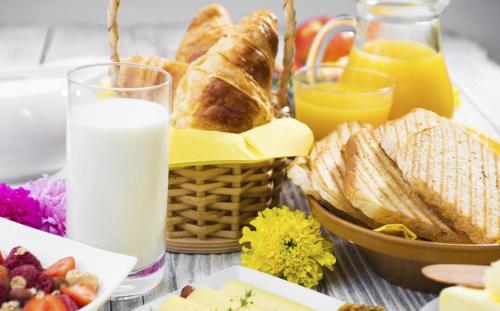 a table with a basket of bread and a glass of milk at Residence Kariri Beach Cumbuco in Cumbuco