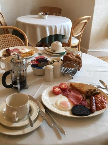 een tafel met borden ontbijt erop bij Rivendell Guest House in Keswick