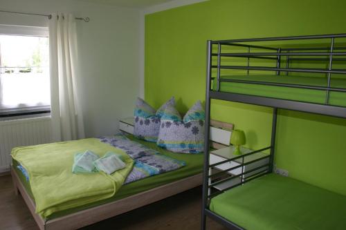ゼープニッツにあるFerienhaus Sonneneckの緑の壁のベッドルーム(二段ベッド付)