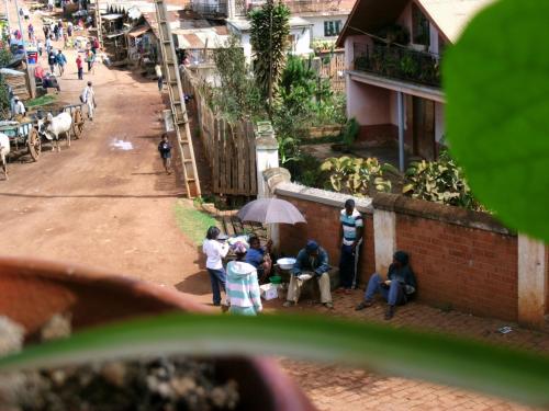 a group of people sitting under an umbrella on a street at Marciloui in Antsirabe