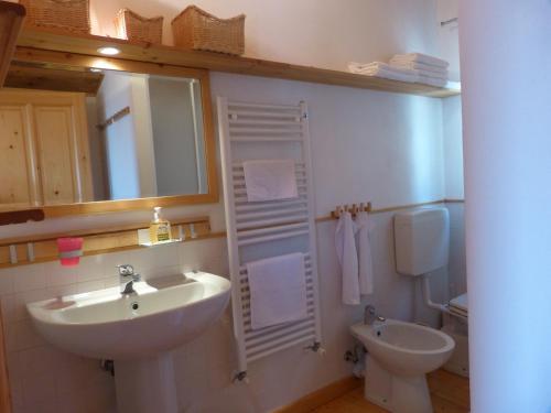 W łazience znajduje się umywalka, toaleta i lustro. w obiekcie Belvedere Lodge w mieście Chiavari