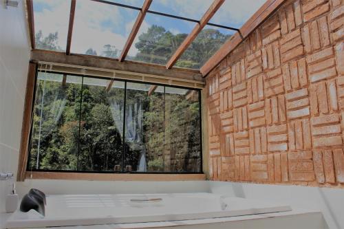 baño con ventana grande y bañera en Pousada Sitio e Poesia, en Teresópolis