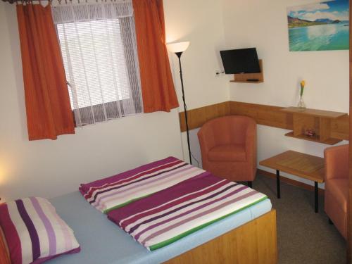 a small room with a bed and a chair at Penzion Pod Vápenkami in Strážnice