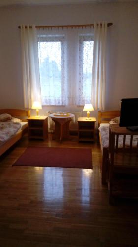 a room with two beds and two tables and two lamps at Gospodarstwo Agroturystyczne-Pensjonat SAD in Podgórzyn