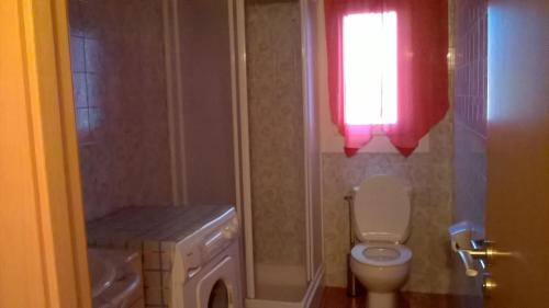 a bathroom with a toilet and a sink and a window at Appartement A Mas Oliva in Roses