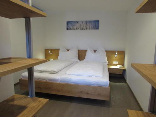 um quarto com uma cama com lençóis brancos e almofadas em Appartement Sprung em Radstadt