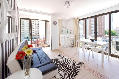 a living room with a blue couch and a table at My Pretty Payma Apartamentos in Benidorm