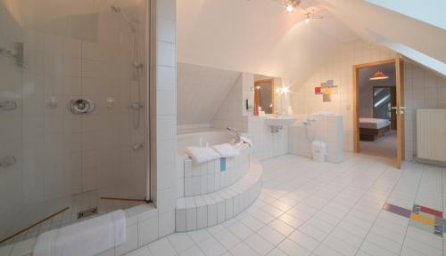 La salle de bains est pourvue d'une douche, d'une baignoire et d'un lavabo. dans l'établissement Hotel am Wasen, à Freiberg am Neckar