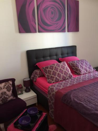 a bedroom with two beds with pink and purple pillows at Chambres dans guest house Centre ville in Menton