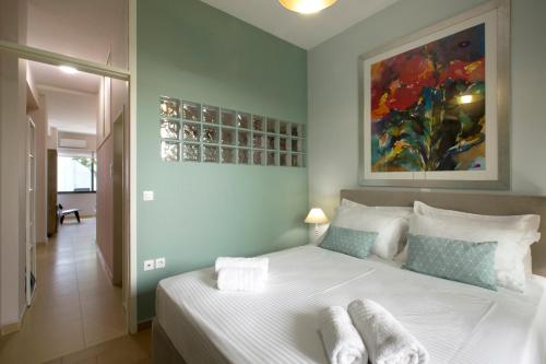 a bedroom with a large white bed with a painting on the wall at Under the shade of Acropolis in Athens