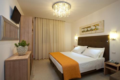 Habitación de hotel con cama y lámpara de araña. en Hotel Ristorante Cesare, en Savignano sul Rubicone