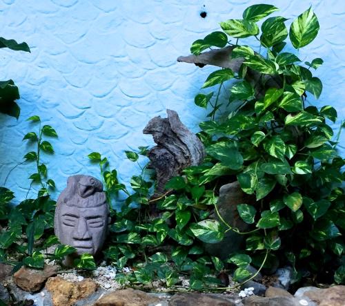 a garden with a statue next to a plant at Tico Adventure Lodge in Sámara