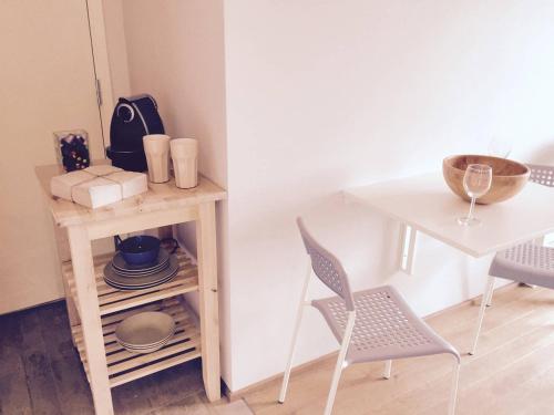 a table and a chair next to a table with plates and a bowl at Knudsen Apartment in Bergen