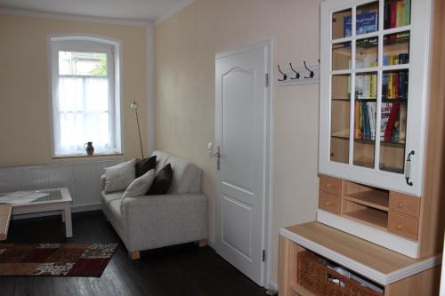 a living room with a chair and a book shelf at Ferienwohnung Westwind in Schüller