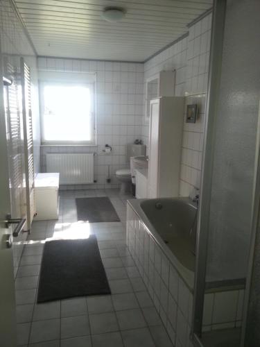 a bathroom with a tub and a sink and a refrigerator at Die Gefährten in Oberhausen