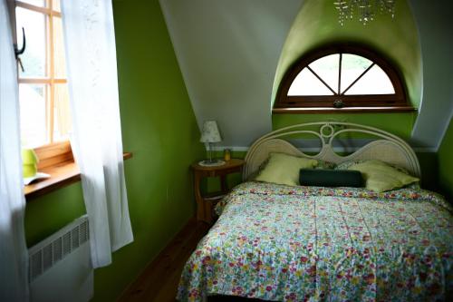 ビャウォヴィエジャにあるBiałowieski Dworek do 10 Gościの緑のベッドルーム(ベッド1台、窓付)