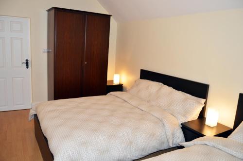 a bedroom with a bed and a cabinet and two lamps at Ash Tree Cottage in Bangor