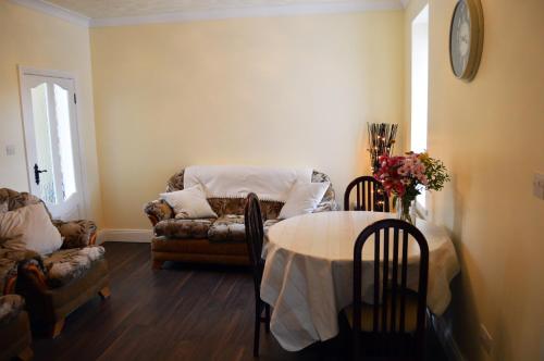 uma sala de estar com uma mesa e um sofá em Ash Tree Cottage em Bangor